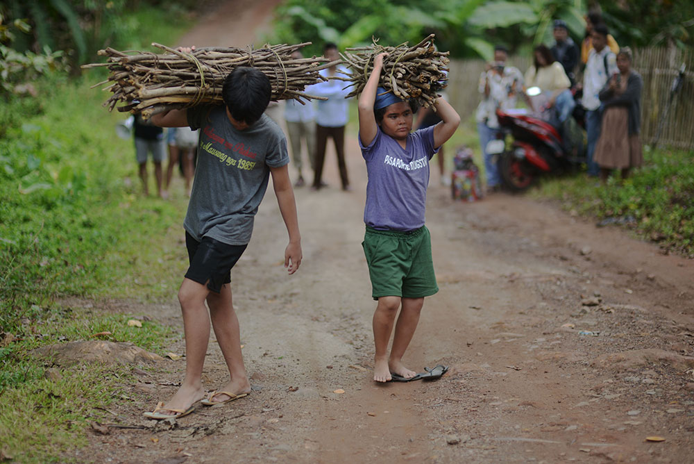 Two young boys carrying wood on top of their heads in Cinemalaya movie, Batsoy