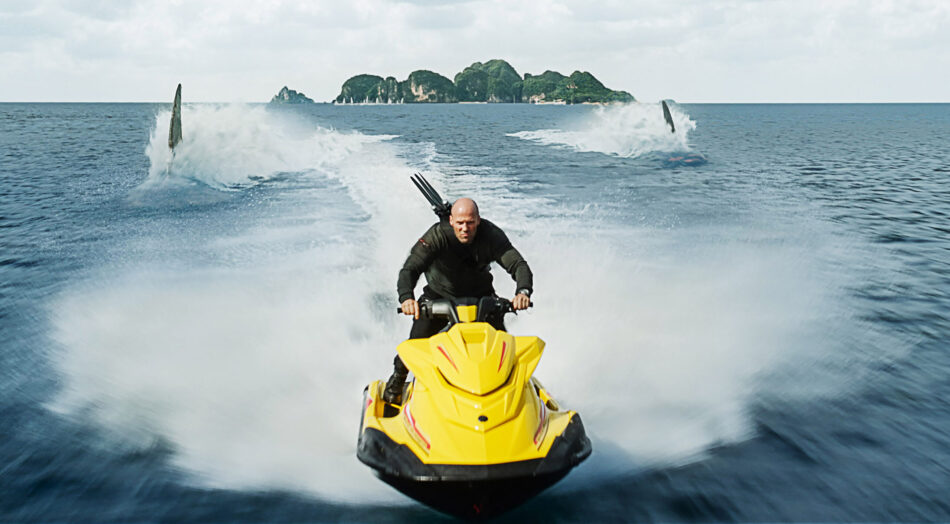 Jason Statham on a jetski with megs behind him in Meg 2: The Trench