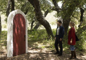 Colin Farrel and Margot Robbie in front of a red door in A Big Bold Beautiful Journey